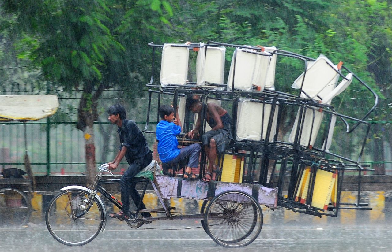 A rickshaw driver bikes through heavy rain in Allahabad, Uttar Pradesh state, on June 24.