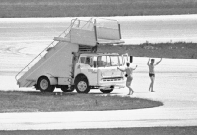 In this July 1972 photo, FBI agents in Miami, wearing only swim trunks, per a hijacker's instructions, prepare to deliver a case containing a $1 million ransom to a hijacked Delta DC8 jet.