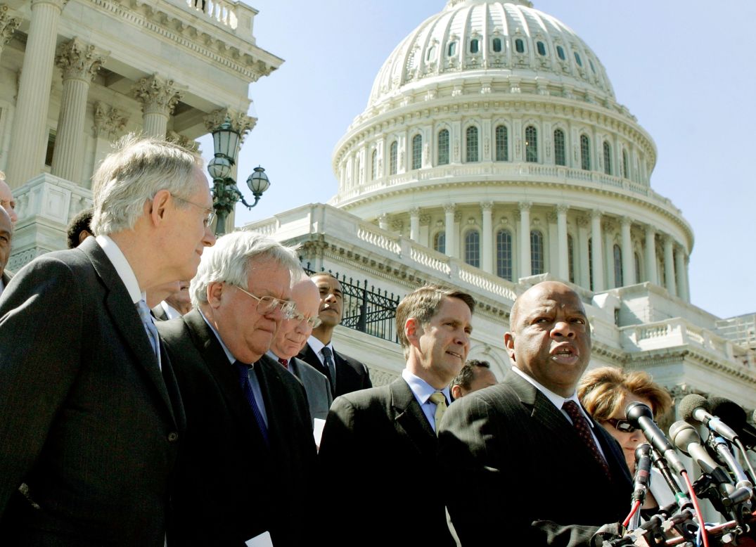 Rep. John Lewis speaks after bipartisan House and Senate officials met to voice support for reauthorizing the Voting Rights Act for an additional 25 years on May 2, 2006. From left, Senate Minority Leader Harry Reid, House Speaker Dennis Hastert, Senate Majority Leader Bill Frist and other officials listen during the media conference.