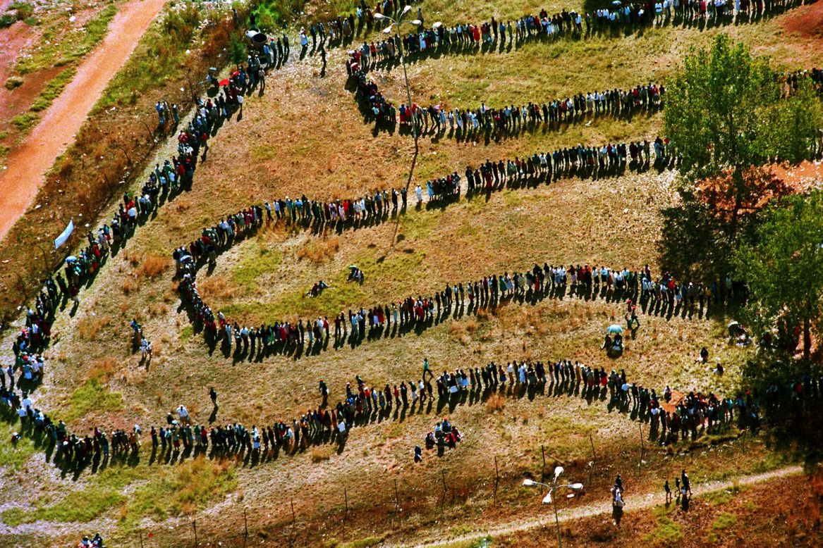 On April 27, 1994, a long line of people snake toward a polling station in the black township of Soweto outside of Johannesburg in the nation's first all-race elections.