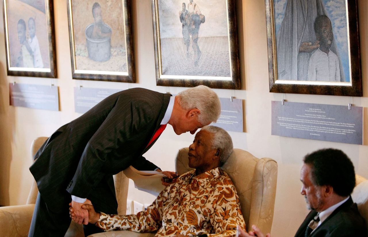 Former U.S. President Bill Clinton leans down to whisper to former South African President Nelson Mandela during a visit to the Nelson Mandela Foundation on July 19, 2007, in Johannesburg.