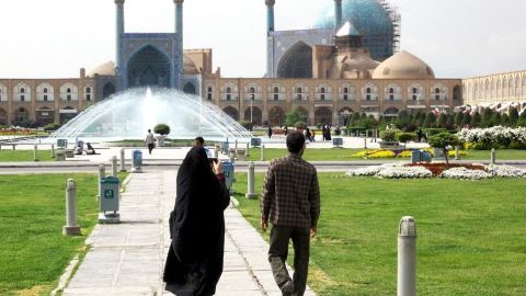 A couple crosses Naqsh-e Jahan Imam Square toward the Masjed-e Shah in Isfahan, Iran. Imam Square is the second largest city square in the world, surpassed only by Tiananmen in Beijing.