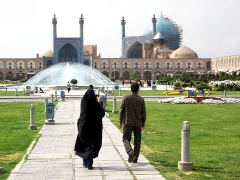 A couple crosses Naqsh-e Jahan Imam Square toward the Masjed-e Shah in Isfahan, Iran. Imam Square is the second largest city square in the world, surpassed only by Tiananmen in Beijing.