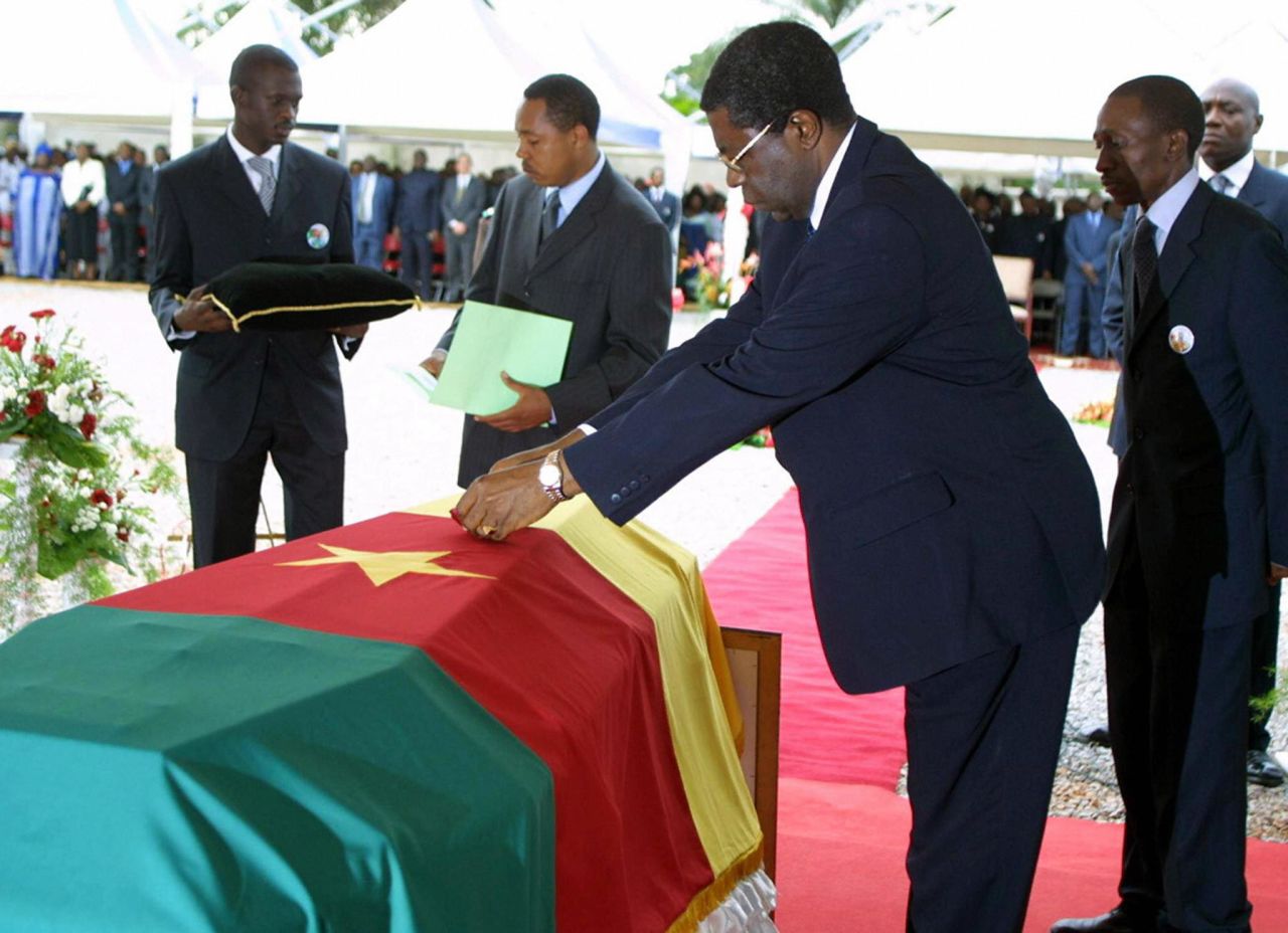Then Prime Minister Peter Musonge lays a posthumous medal -- the Commander of the National Order of Valor -- on Foe's coffin at his burial in Yaounde. 