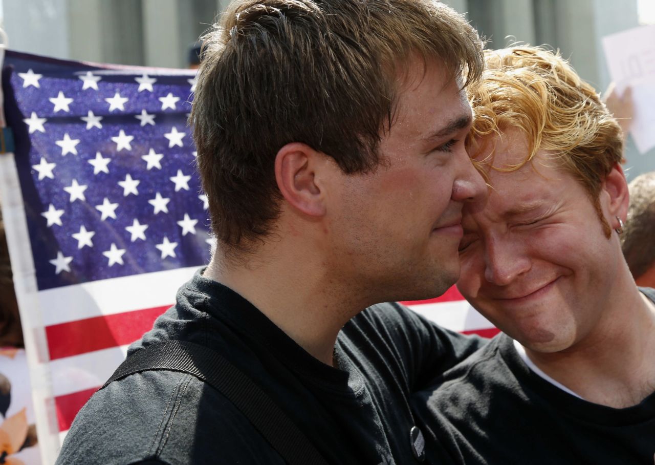Michael Knaapen, left, and his husband, John Becker, react to the rulings in Washington.