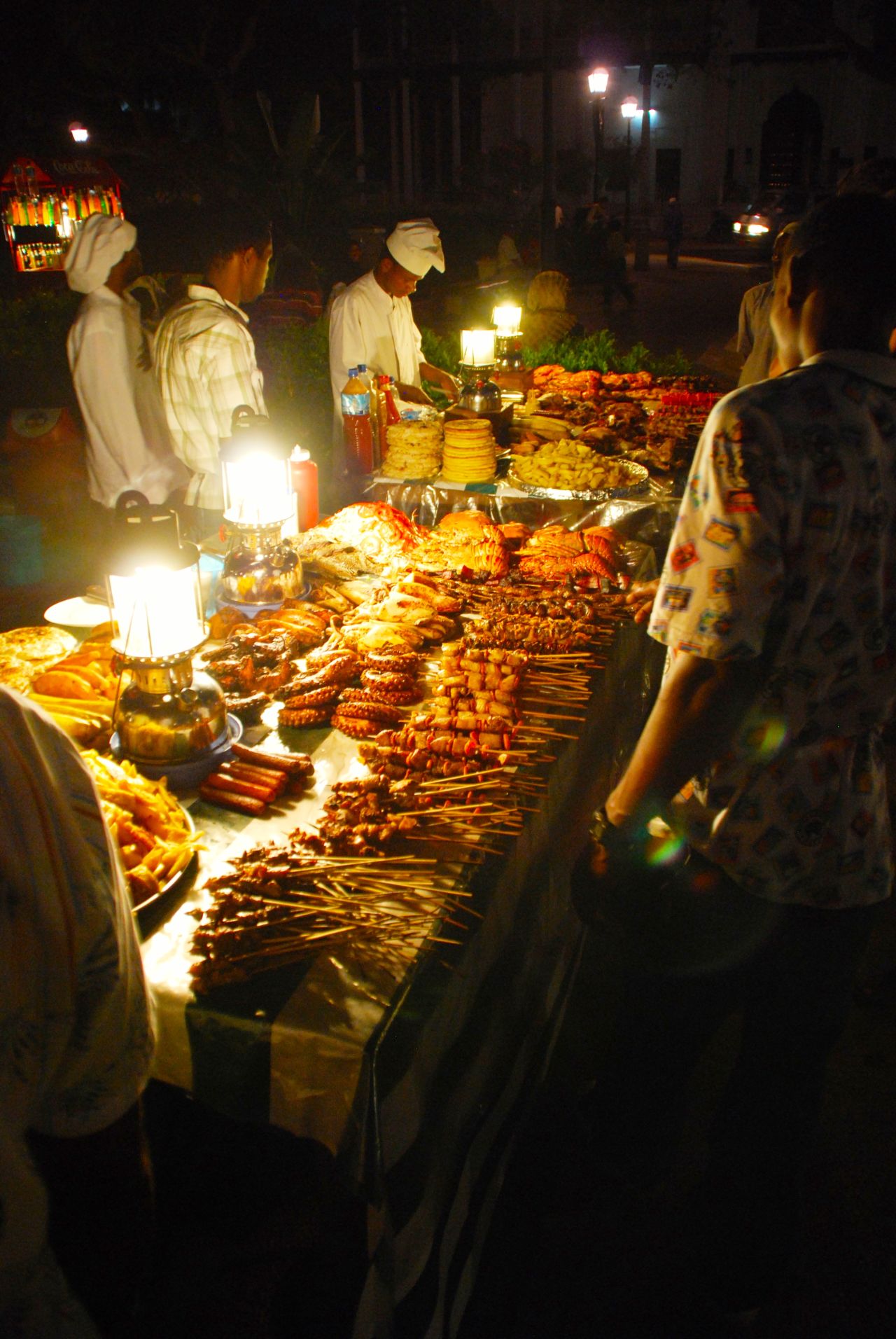 People wander the food stalls at Forodhani Gardens for snacks including Zanzibar pizza, sugarcane drink and fresh seafood. 