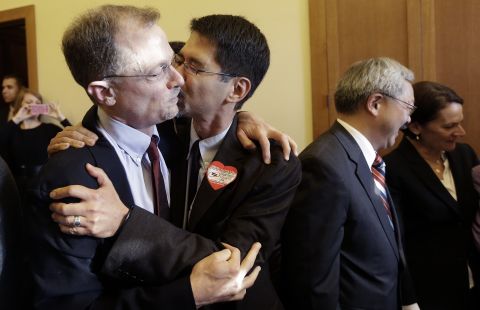 John Lewis, left, gets a kiss from his partner Stuart Gaffney at City Hall in San Francisco.
