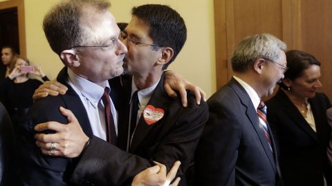 John Lewis, left, gets a kiss from his partner Stuart Gaffney at City Hall in San Francisco.