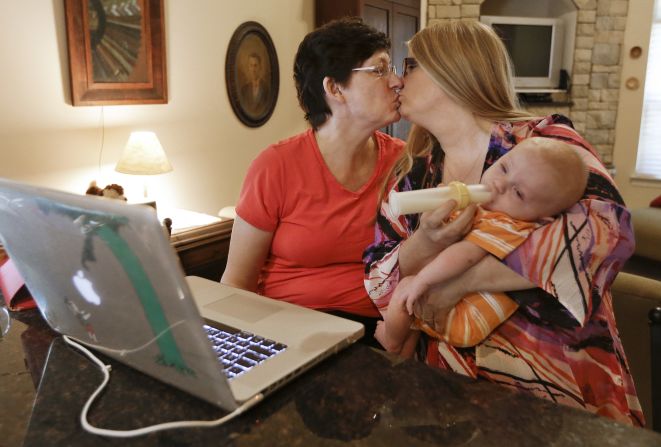 Julia Tate, left, kisses her wife, Lisa McMillin, in Nashville, Tennessee, after the reading the results of the <a href="index.php?page=&url=http%3A%2F%2Fwww.cnn.com%2F2013%2F06%2F26%2Fpolitics%2Fscotus-same-sex-main%2Findex.html">Supreme Court rulings on same-sex marriage</a> on Wednesday, June 26. The high court struck down key parts of the <a href="index.php?page=&url=http%3A%2F%2Fwww.cnn.com%2Finteractive%2F2013%2F06%2Fpolitics%2Fscotus-ruling-windsor%2Findex.html">Defense of Marriage Act</a> and cleared the way for same-sex marriages to resume in California by rejecting an appeal on the state's <a href="index.php?page=&url=http%3A%2F%2Fwww.cnn.com%2Finteractive%2F2013%2F06%2Fpolitics%2Fscotus-ruling-perry%2Findex.html">Proposition 8</a>.