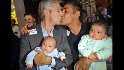 Chris Roe, left, and Roby Chavez celebrate while holding their soon-to-be-adopted children as the ruling is announced in San Francisco.