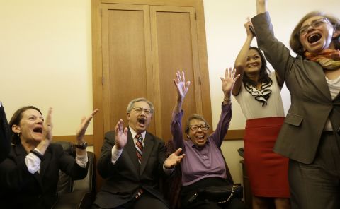 San Francisco Mayor Ed Lee, second from left, and Phyllis Lyon, center, celebrate at the mayor's office in San Francisco.