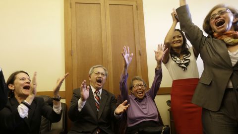San Francisco Mayor Ed Lee, second from left, and Phyllis Lyon, center, celebrate at the mayor's office in San Francisco.