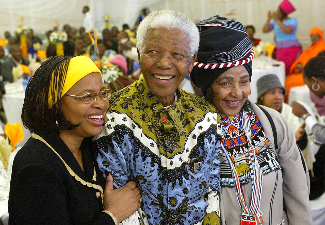 Nelson Mandela celebra sus 86 años con su esposa, Graca Machel Mandela, a la izquierda, y su ex esposa Winnie Madikizela-Mandela en su ciudad natal rural de Qunu en la Provincia Oriental del Cabo en 2004. 