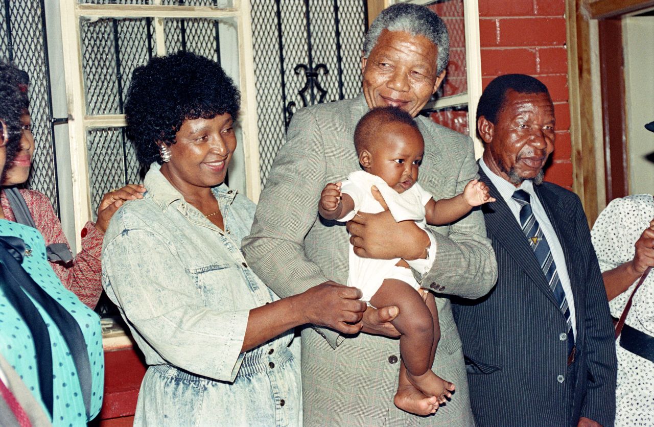 Nelson Mandela and his then-wife, Winnie, play with their grandchild Bambatha at their Soweto home in 1990.