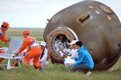 Nie Haisheng (4th R) sits inside the return capsule of the Shenzhou 10 spacecraft that landed after a 15-day mission in space -- China's longest manned space mission.