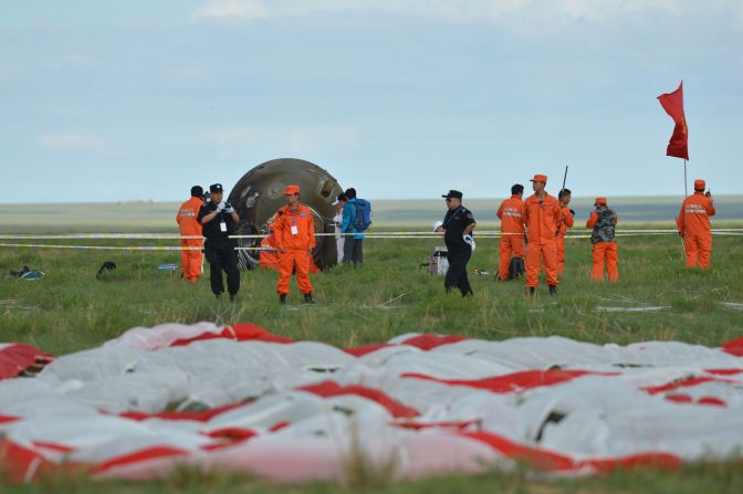 Technicians inspect the return capsule of the Shenzhou 10 spacecraft.