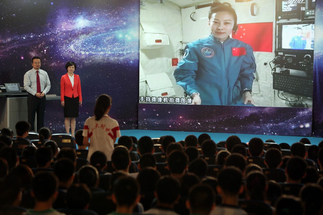 A girl in a school in Beijing asks Chinese female astrounaut Wang Yaping questions as Wang delivers a lesson to students from Tiangong-1 space module on June 20, 2013. 