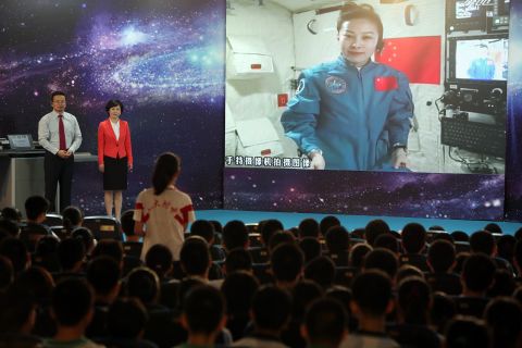 A girl at a Beijing school asks Chinese astrounaut Wang Yaping (Top R) questions as Wang delivers a lesson to students while orbiting in the Tiangong-1 space module on June 20.