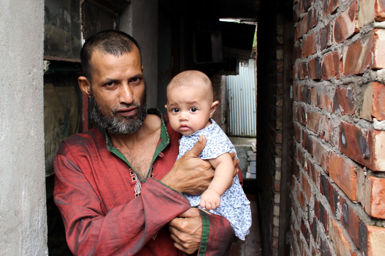 Mojibor, a 42-year old refugee from Bangladesh, holds his four-month old child in the village of Ping Che, Hong Kong on June 25, 2013. Mojibor and other asylum seekers in Hong Kong are legally forbidden to work, and dwell for years in decrepit housing on meager aid while awaiting a determination on their refugee status.