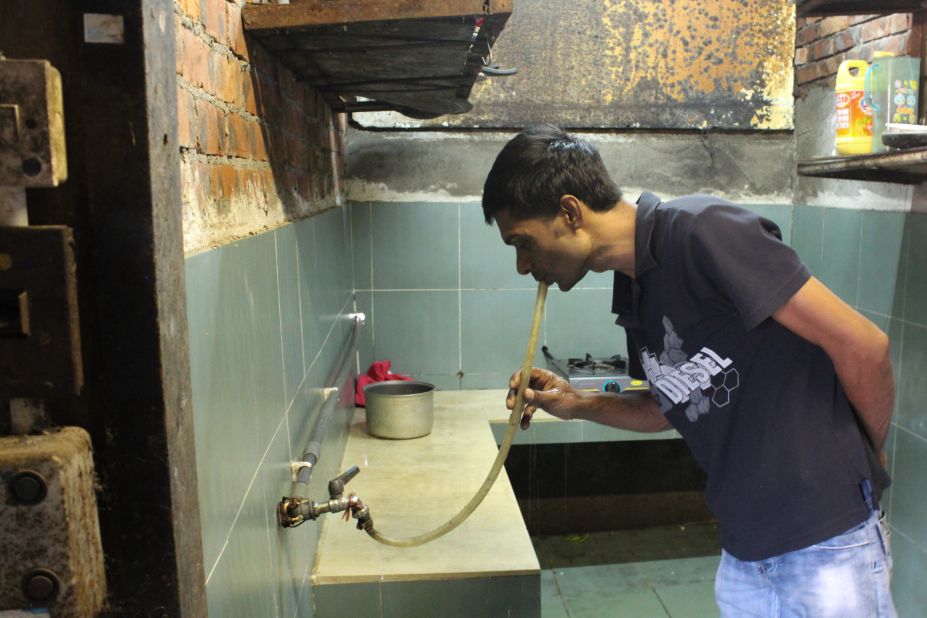 Saidur Rahman, a refugee from Bangladesh, drinks water from a hose in the slum of Ping Che, Hong Kong on June 25, 2013. Rahman and other asylum seekers in Hong Kong receive a housing allowance of $1,200 HKD ($155) a month, which barely covers rent for the most rudimentary housing.