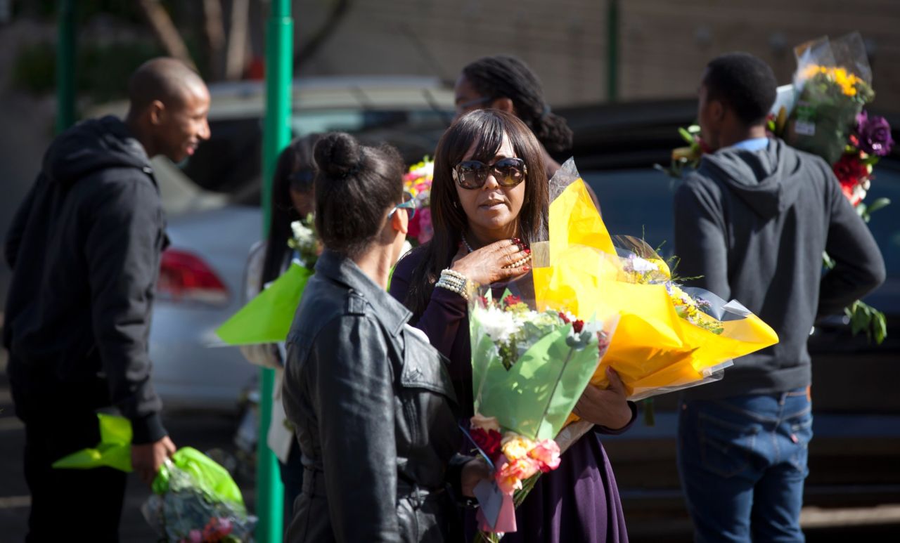 Mandela's granddaughter Ndileka Mandela and other family members collect flowers left by well-wishers on June 27.