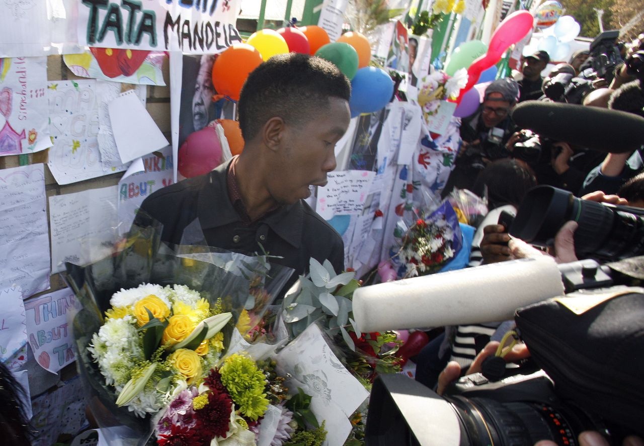 A member of Mandela's family is swamped by the media on June 27 while collecting flowers from well-wishers.