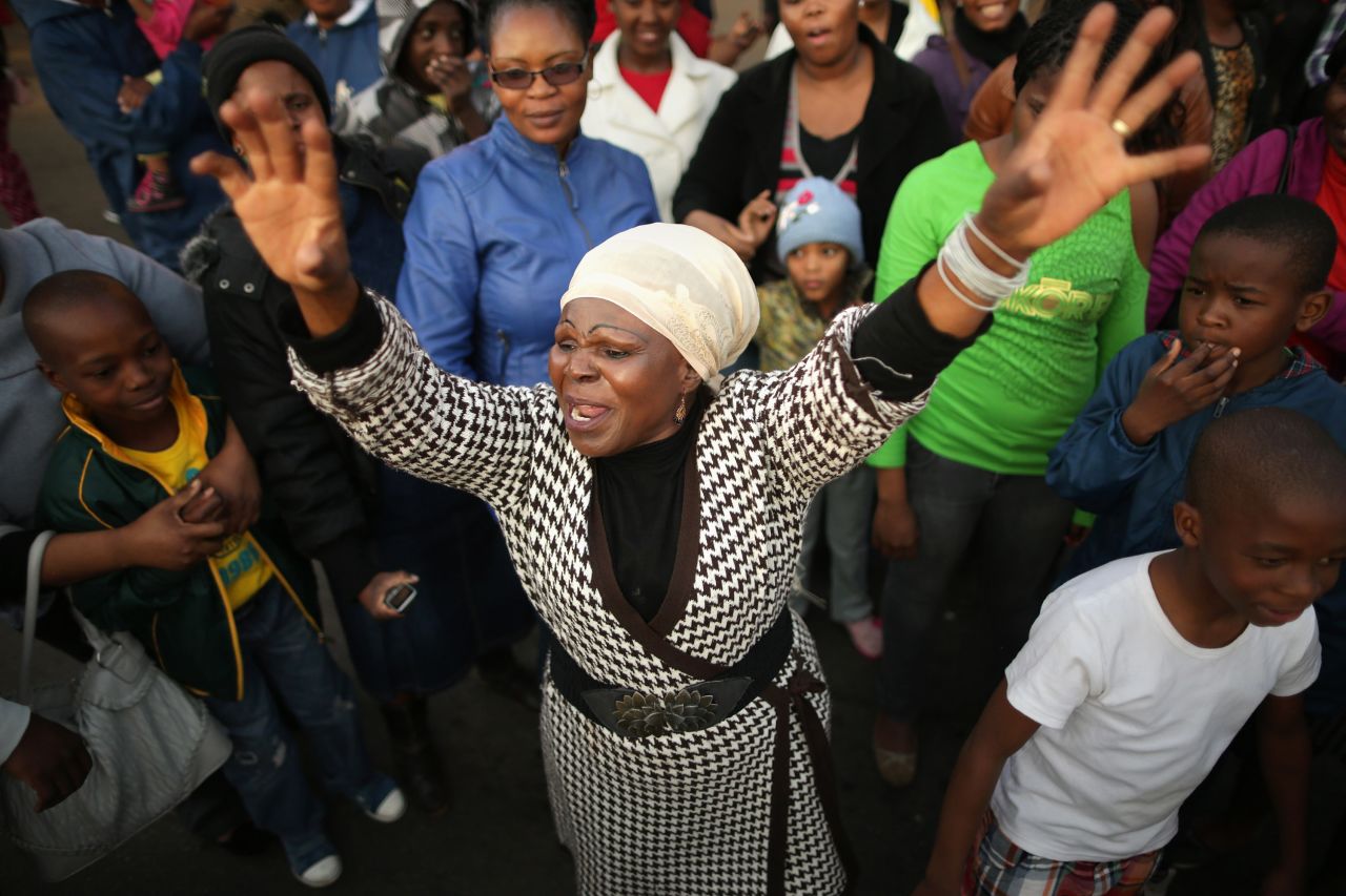 Florence Nyadzani leads those gathered in songs and cheers of support outside the hospital on June 25.