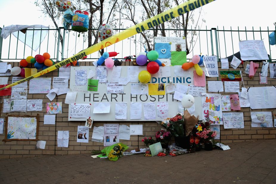 Messages, paintings, cards and flowers are posted to a wall outside the hospital on June 25.