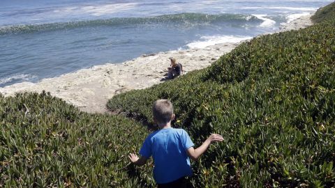 Bryson Hubbard, 7, walks down a path leading to a sea cliff as his mother Vanessa Singer waits for him on a hot day in Santa Cruz, California, on June 27.