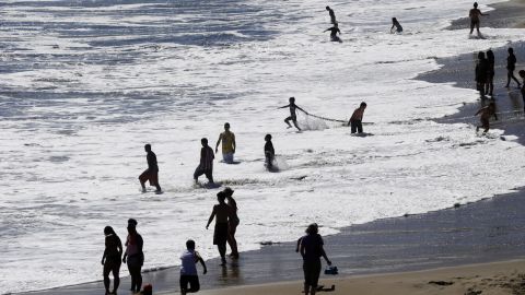 Beach-goers enjoy the surf at Natural Bridges in Santa Cruz on June 27.