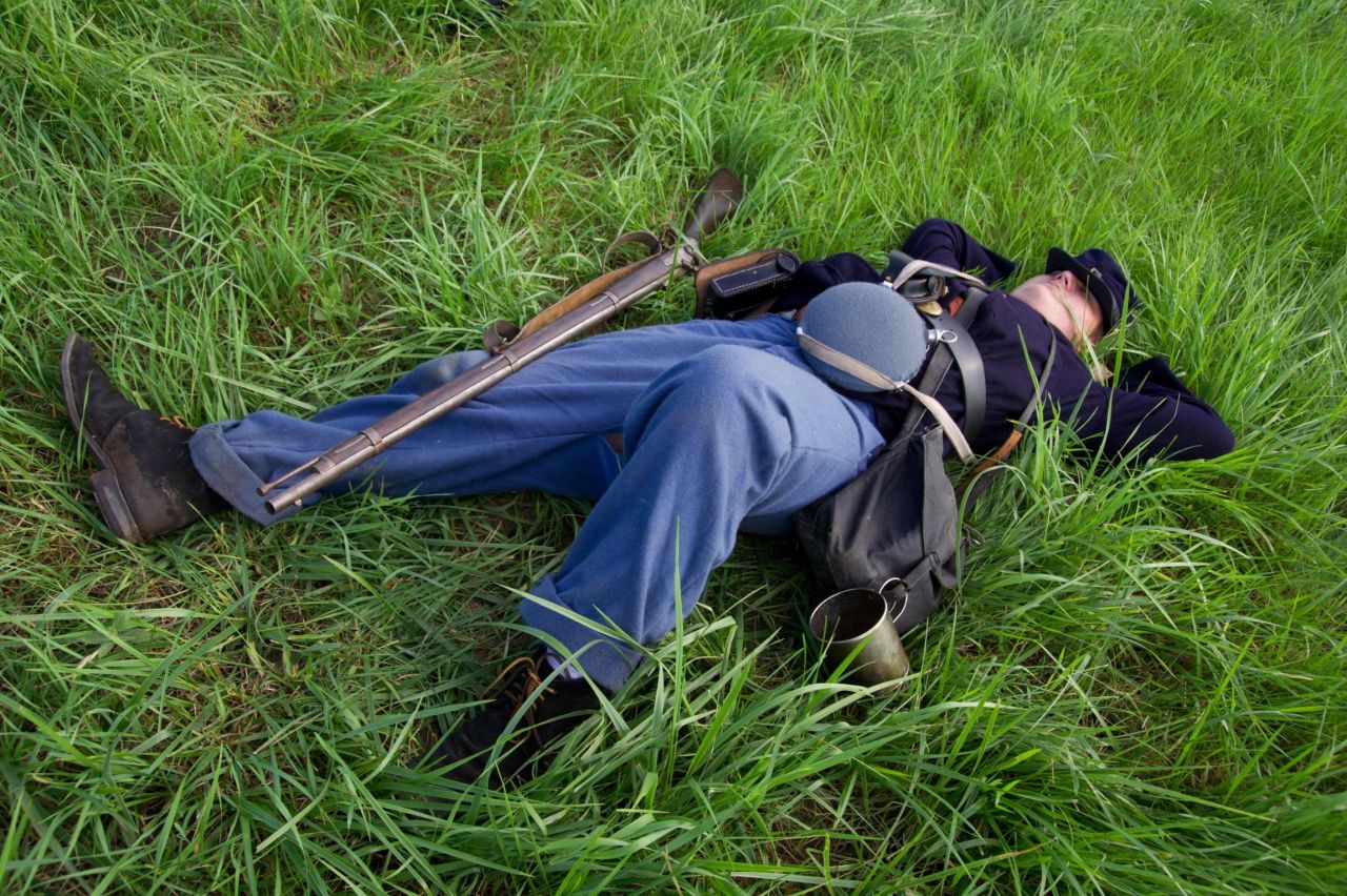 A Union infantryman lies on the ground during a reenactment in Gettysburg on Friday, June 28.