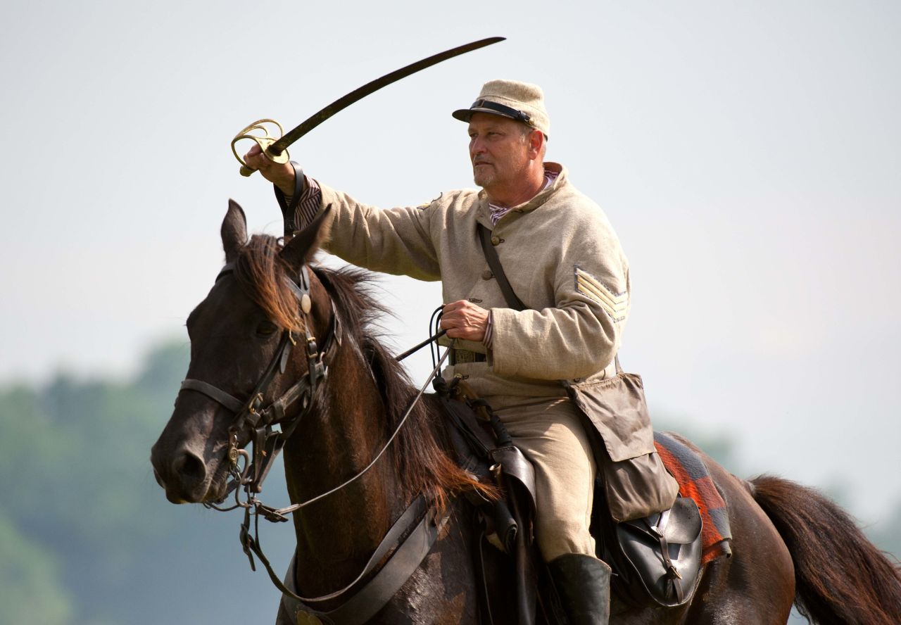 A Confederate sergeant waves his saber to rally troops during a reenactment. Another such event is planned next weekend.