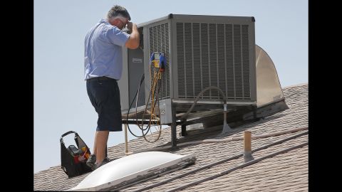 Michael Hawks, a warranty supervisor for an air conditioning company, wipes his brow while inspecting a unit in Phoenix on June 28.