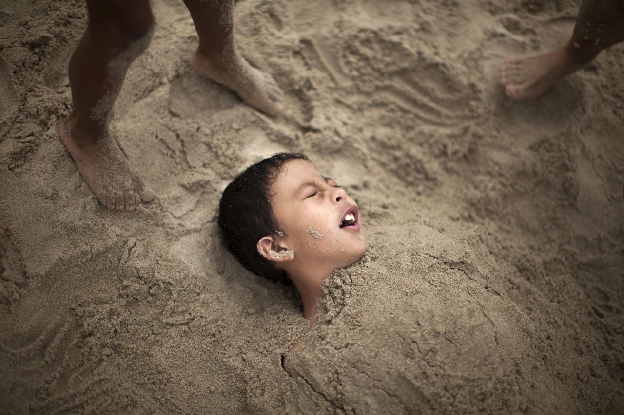 R.J. Hernandez, 8, of El Campo, Texas, is buried in sand as he tries to stay cool in Santa Monica on June 28.