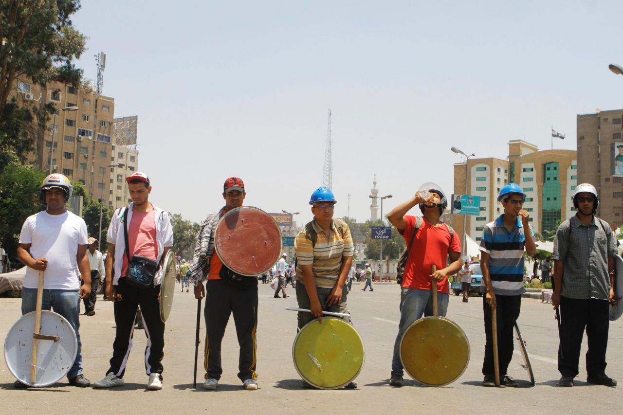 Morsy supporters, armed with sticks and shields, stand guard at their protest site in Cairo on June 29.