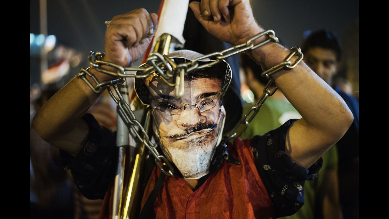 A chained protester wearing a picture of Morsy participates in an anti-government protest in Tahrir Square on Wednesday, June 26.