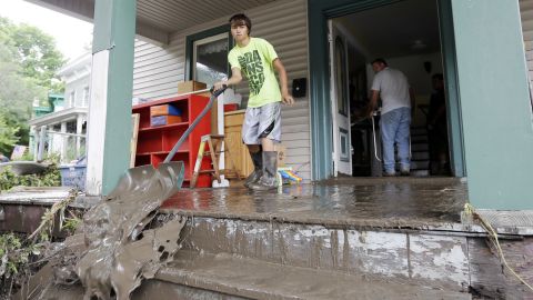 Brendan Hazzard shovels mud from a friend's flood-damaged home on Friday, June 28, in Fort Plain, New York.
