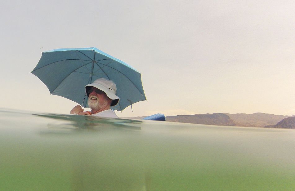 Mike Bouse shades himself with an umbrella as he floats in the water at Lake Mead near Boulder City, Nevada, on Saturday, June 29. 