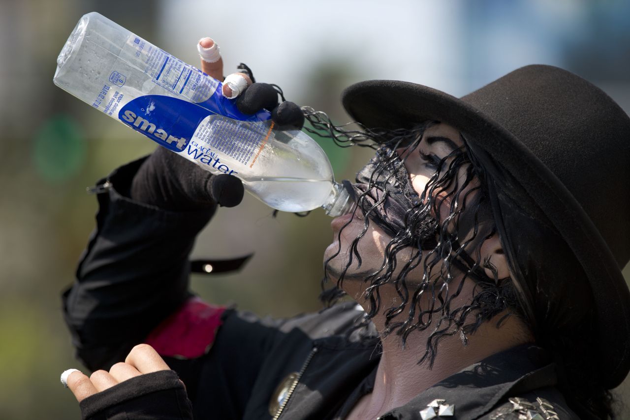 Michael Jackson impersonator Juan Carlos Gomez gulps down some water on Friday, June 28, during a break from posing for photos with tourists along the Las Vegas strip.
