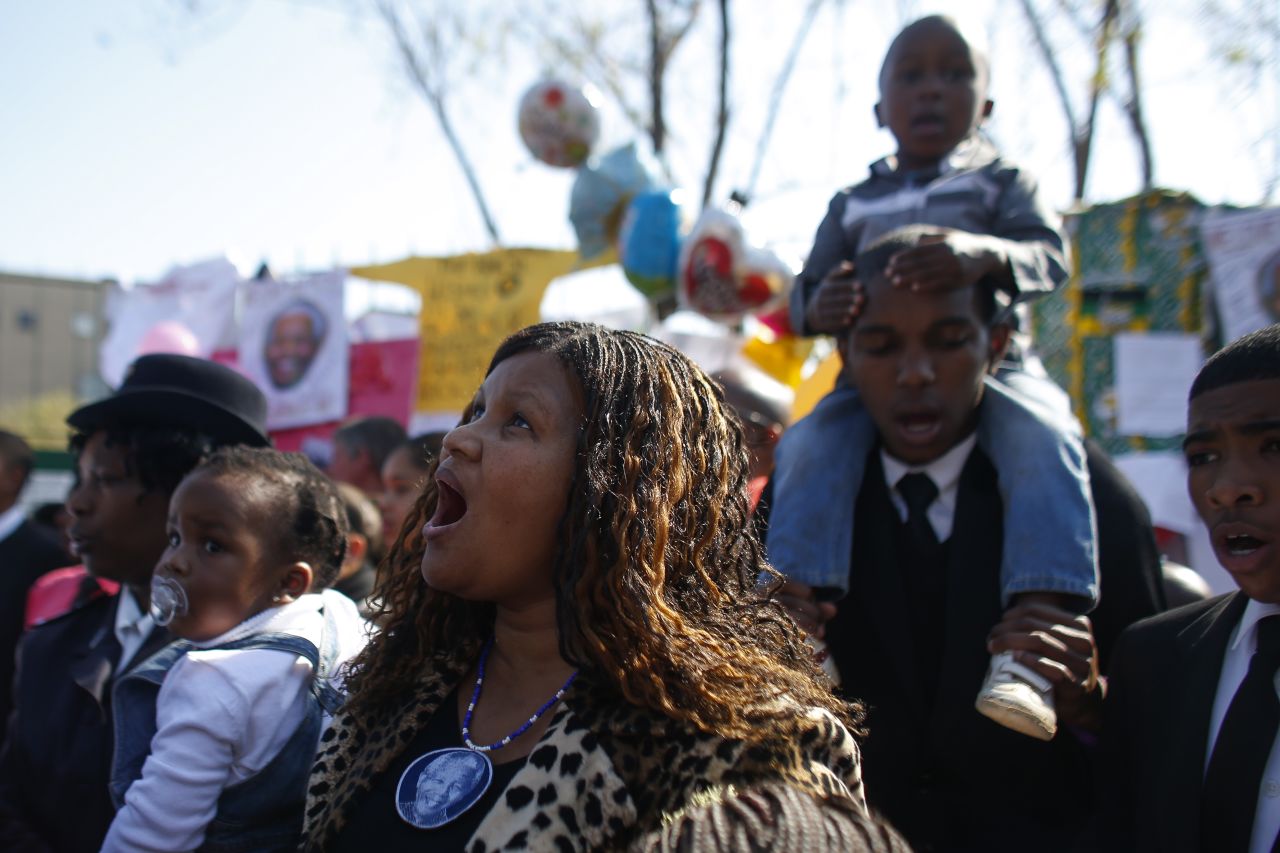Well-wishers sing outside the hospital where former South African President Nelson Mandela is being treated in Pretoria, South Africa, on Sunday, June 30.