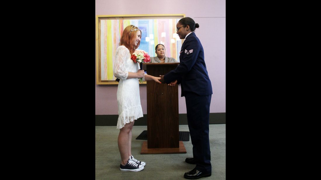 U.S. Air Force Senior Airman Shyla Smith, right, and Courtney Burdeshaw hold hands in the west chapel during their wedding ceremony at the Manhattan Marriage Bureau on Thursday, June 27.