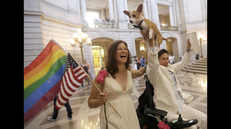 Jen Rainin, left, laughs as her wife, Frances Stevens, holds up their dog, Punum, after they were married in San Fransisco on June 28.