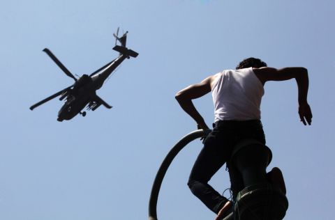 A protester watches an Apache helicopter as it flies over Tahrir Square on June 30. Morsy's opponents stood their ground in the square, where protests two years ago helped topple Hosni Mubarak's 29-year rule.