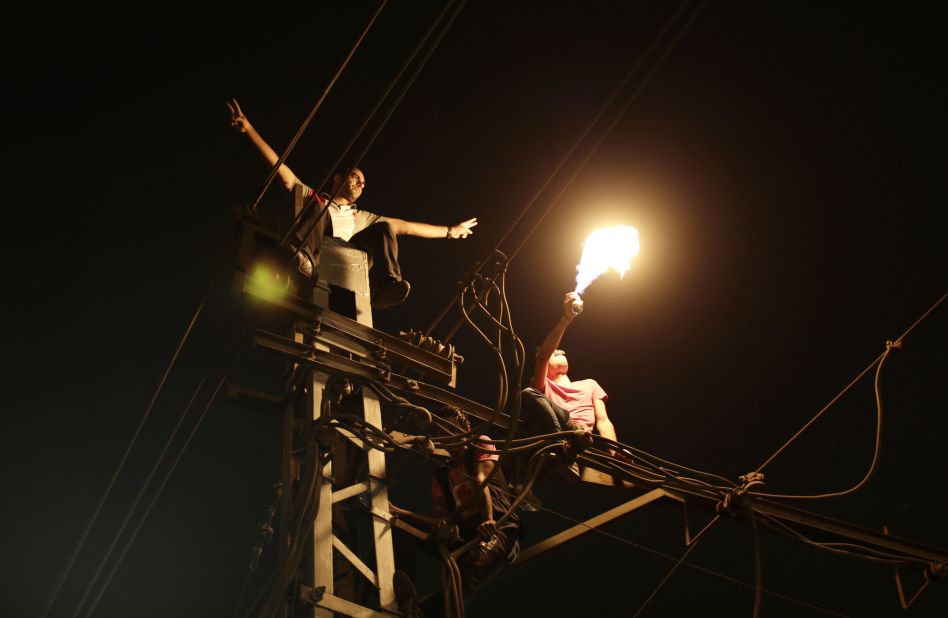 Protesters sit on top of a power pole as they chant slogans against Morsy outside the presidential palace in Cairo on June 30. "Egypt is on the brink of a volcano," government-run newspaper Al-Akhbar said.
