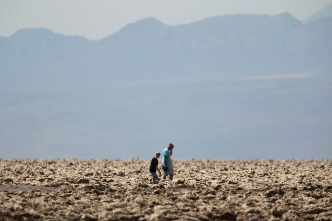 People walk through the "Devil's Golf Course" area of Death Valley, where temperatures were 116 degrees.  
