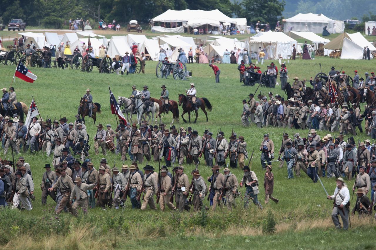 Confederate Civil War reenactors march towards Union positions during Pickett's Charge on June 30.