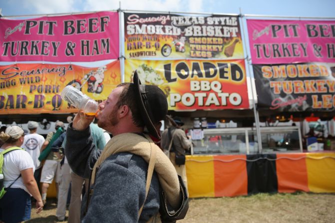 A Confederate Civil War reenactor drinks a sports drink while taking a break from the event on June 30. 