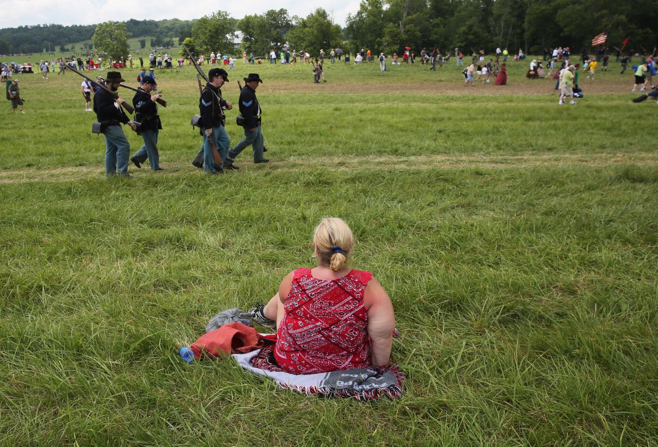 A spectator watches the event on June 30 from a seat on the grass.