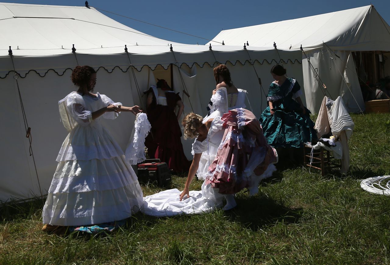 Women remove Civil War-era dresses while participating in the event on June 29. 