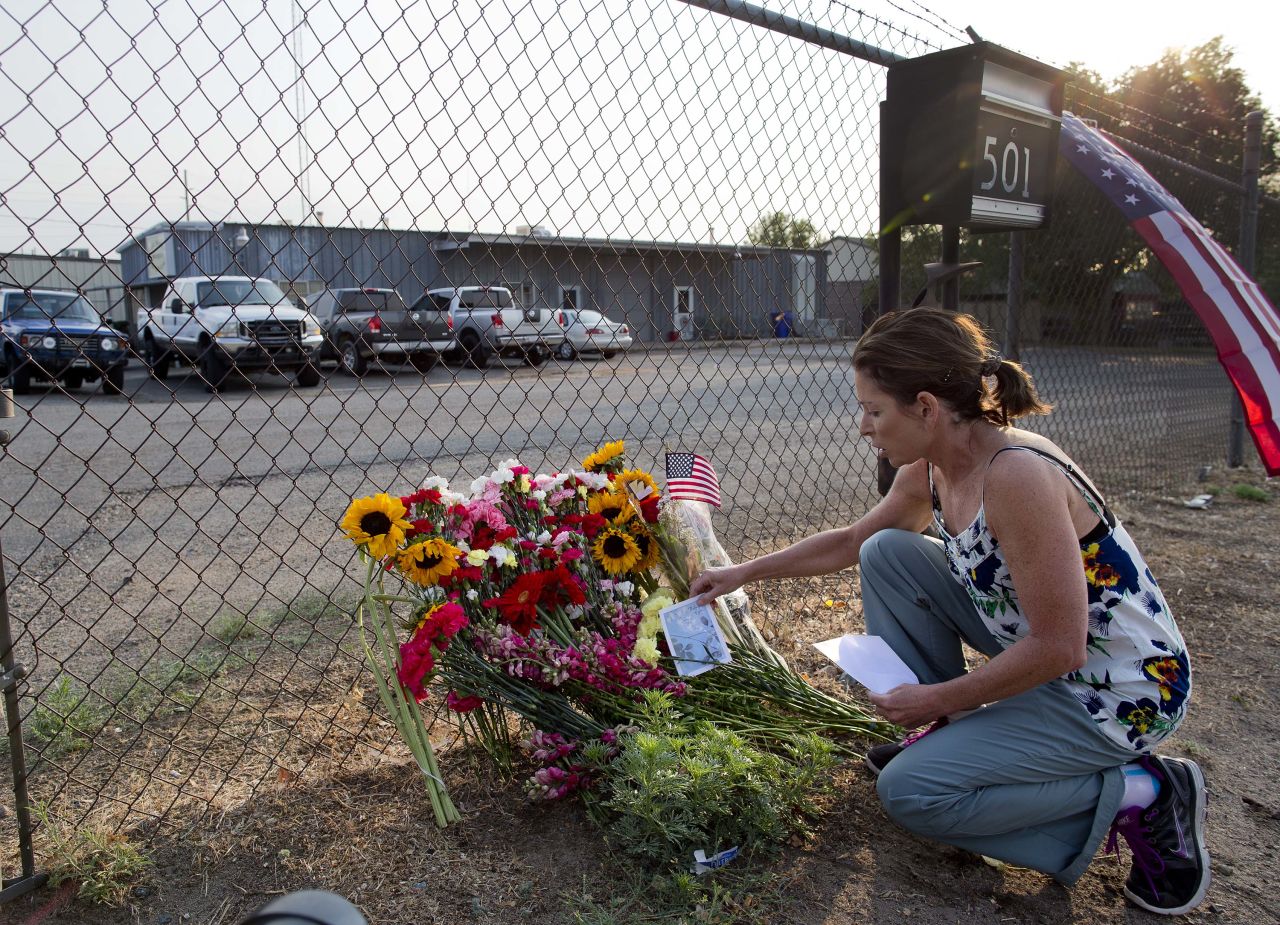 Toby Schultz lays flowers on July 1 at the fence of the fire station in Prescott, Arizona, the home base of 19 firefighters who died in the Yarnell Hill Fire. 